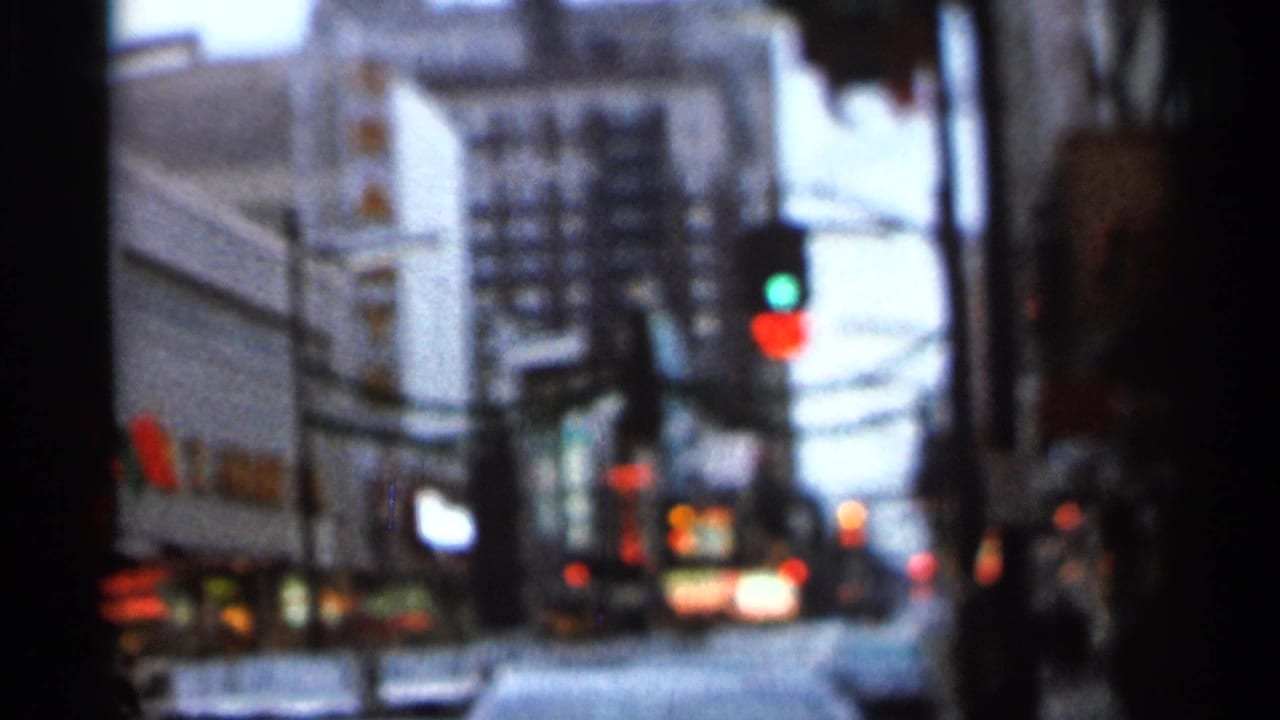 Soft 8mm view of a city street identified by the clip metadata and later title card as Knoxville, Tennessee.