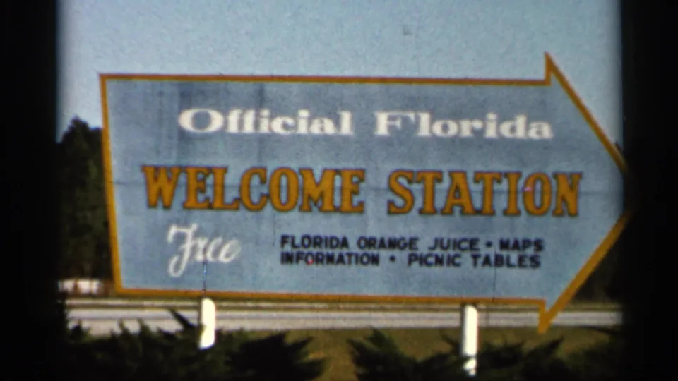 1966 Florida frame with the welcome station arrow sign, including text for free orange juice, maps, information, and picnic tables.