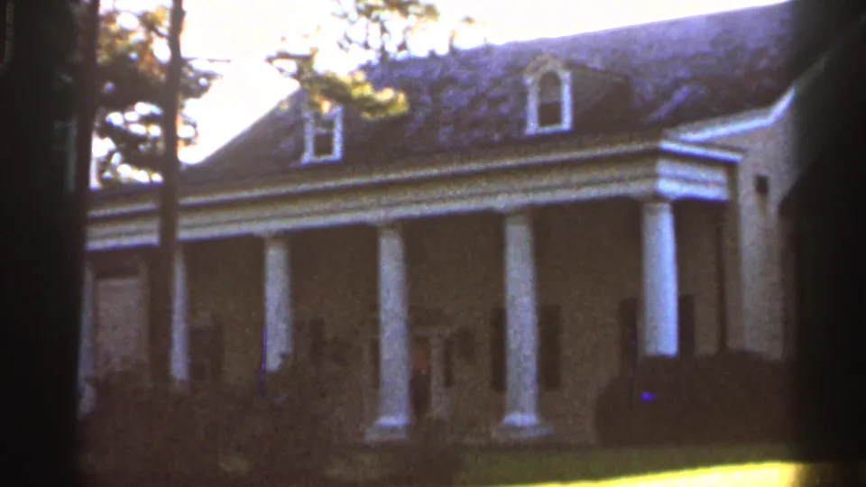 Brightened 1966 Florida exterior of a Southern-style weatherboard house with white columns, shrubs, lawn, and trees.
