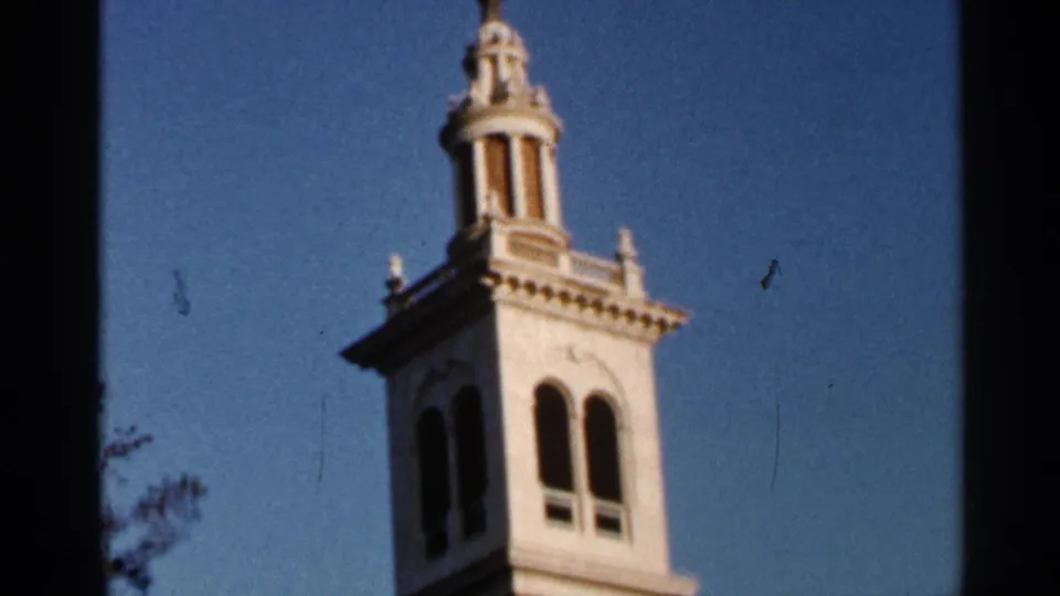 1966 Florida 8mm frame showing a white tower or cupola against blue sky, softly focused within dark film borders.