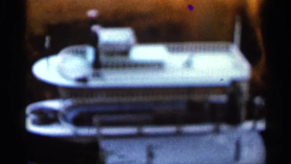 1966 Florida 8mm frame showing the ship model from a similar angle, with its decks, railings, and rounded bow visible.