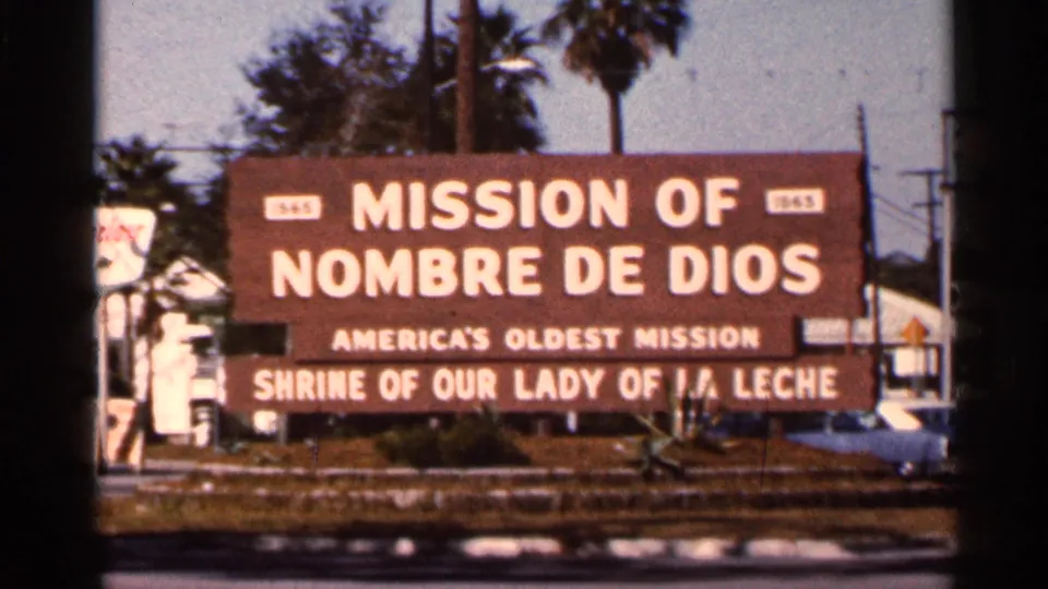 1966 Florida 8mm frame centered on the Mission of Nombre de Dios sign and Shrine of Our Lady of La Leche wording.