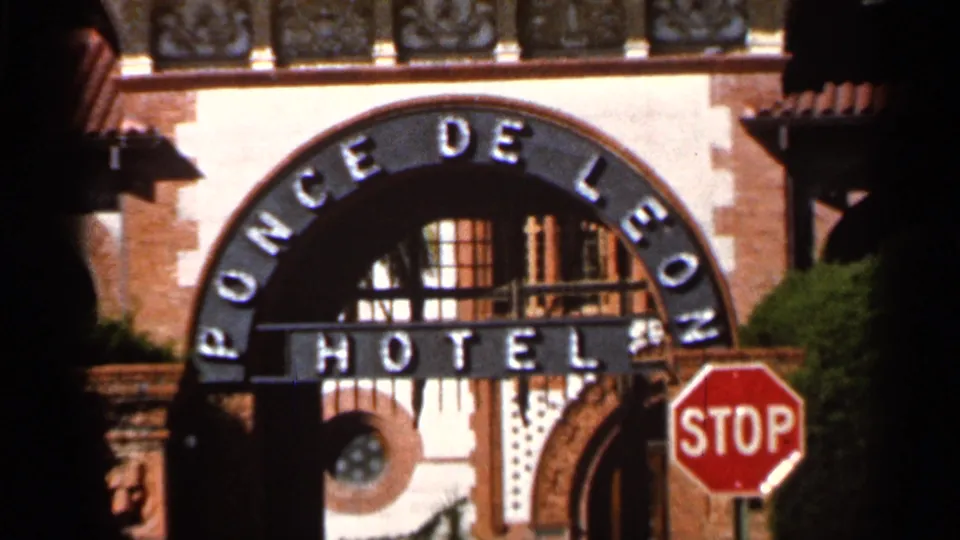 1966 Florida 8mm frame centered on the Ponce de Leon Hotel arch lettering, with a stop sign and ornate entrance architecture visible.