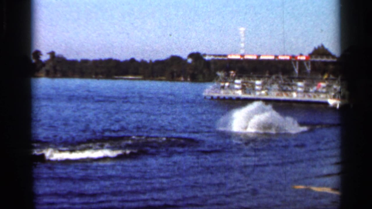 1966 Florida 8mm frame showing a large splash where the skier appears to have fallen near the docked platform.