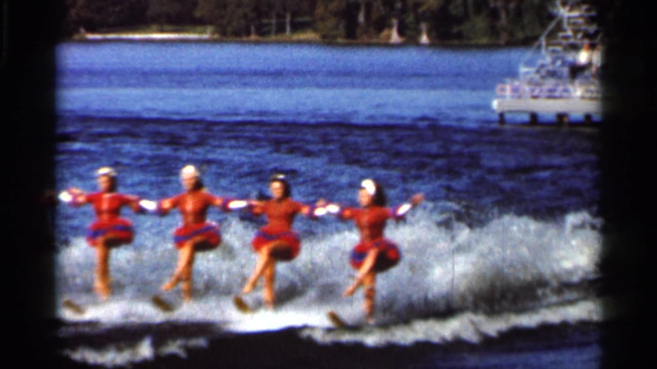 Four women in red-and-blue costumes continue a synchronized water-ski routine on a Florida lake in 1966 home-movie footage.