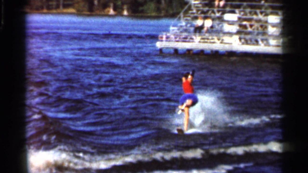 A costumed solo water skier performs a one-legged pose on a Florida lake in 1966 8mm home-movie footage.