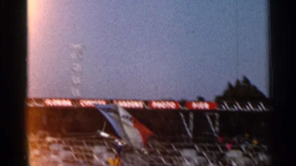 1966 Florida 8mm frame showing a white and orange glider near the Cypress Gardens photo pier sign and waterfront structure.