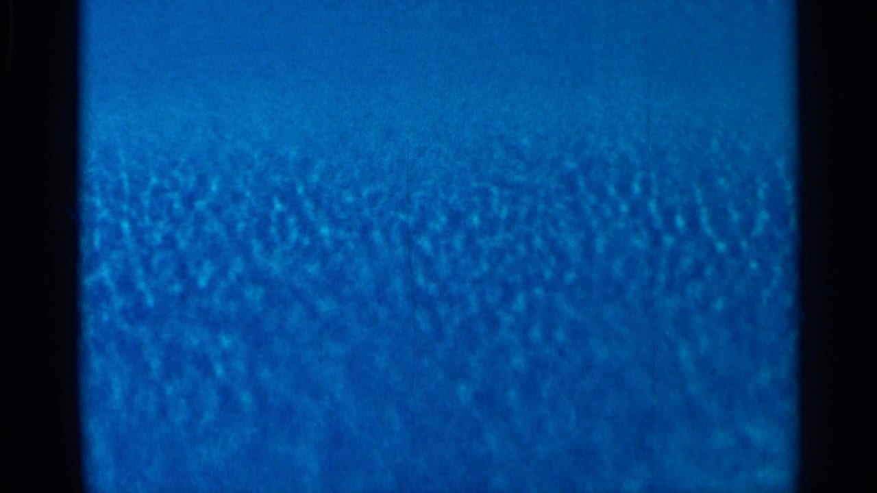 Blue grainy film field bordered by dark frame edges.