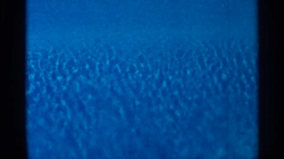 Blue 8mm frame showing a horizontal splice-like transition line and dark vertical film borders.