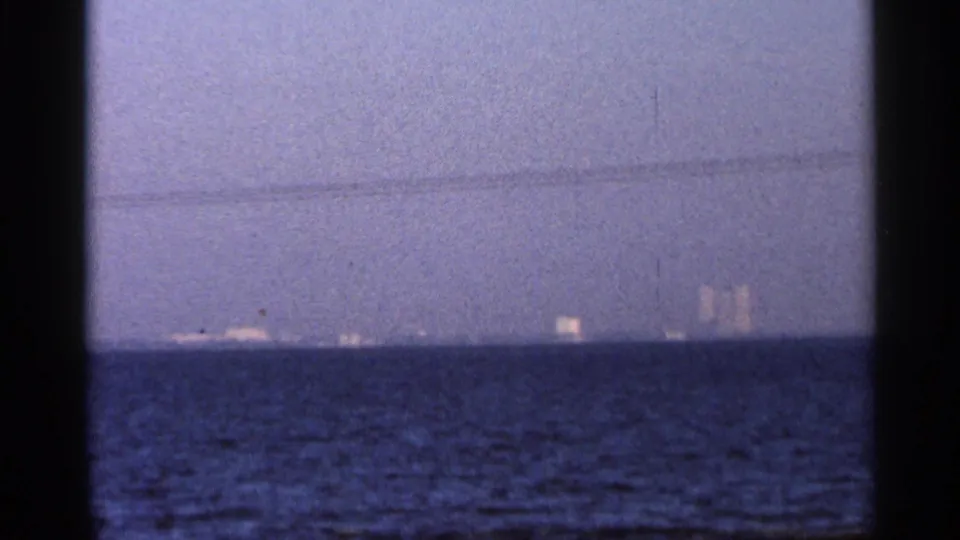 1966 Florida coastal twilight view with open water, a dim horizon, and faint distant lights or structures.