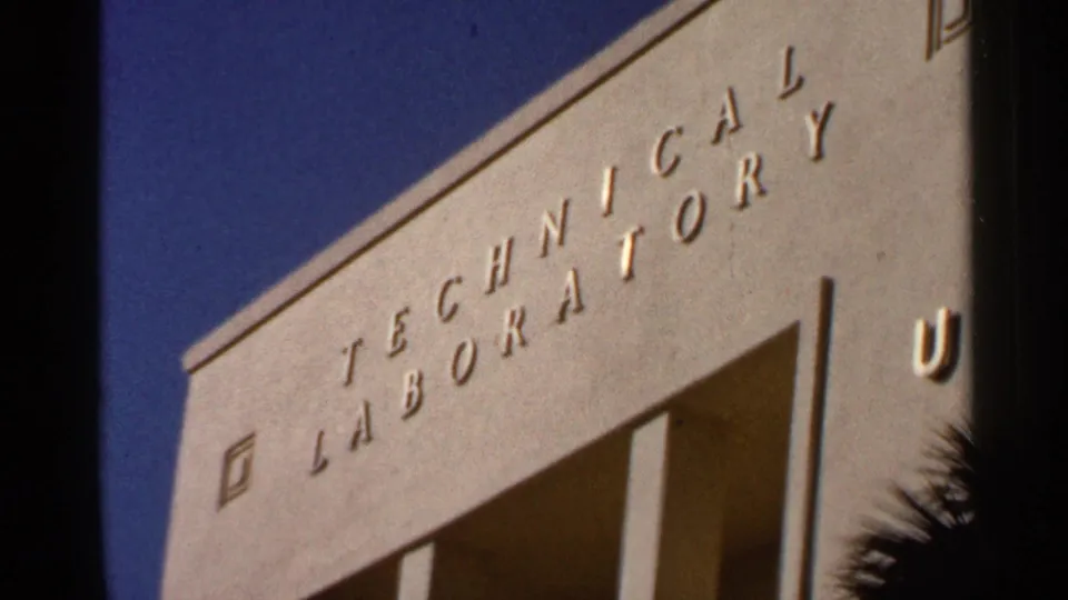 Tilted 8mm frame showing the Technical Laboratory sign on a pale modern building in Florida.