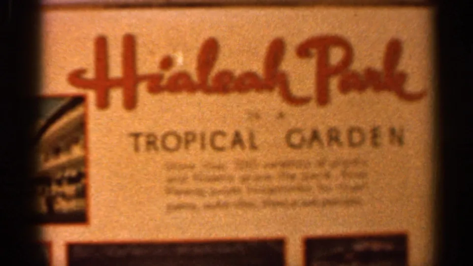 Final 1966 Florida frame of the Hialeah Park Tropical Garden sign, softly focused with visible grain, warm fade, and dark edge shading.