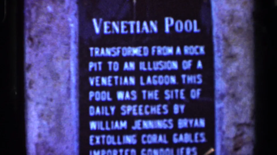 Close 1966 Florida home-movie frame of the Venetian Pool sign describing the pool's rock-pit origin and historic speeches.