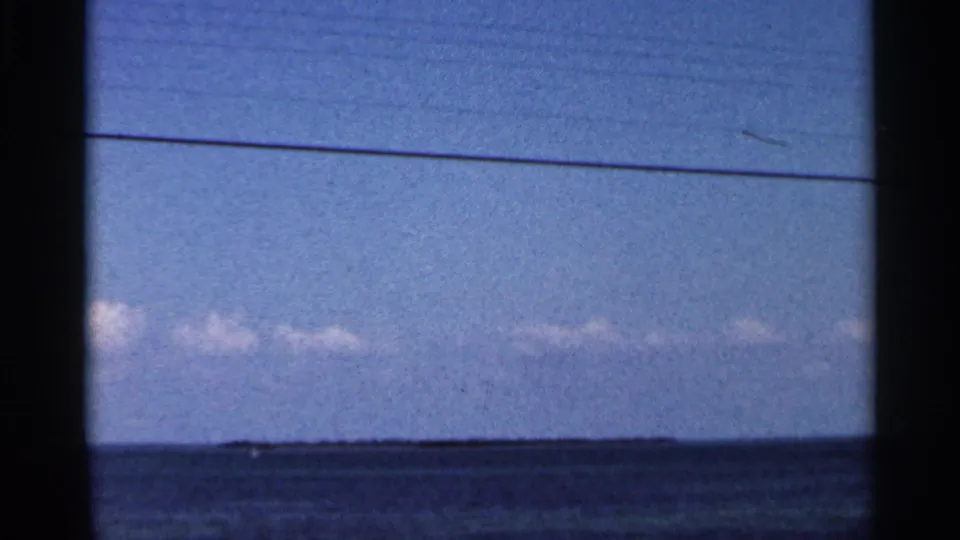 1966 Florida 8mm view of blue ocean, low cloud band, faint horizon detail, and dark window-like borders.