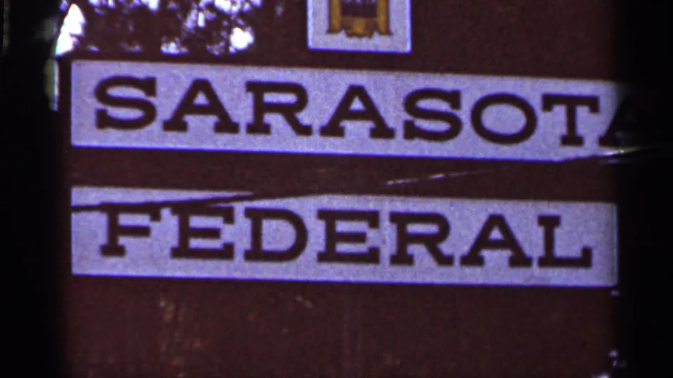 Tight 1966 home-movie view of the Sarasota Federal sign, showing large block lettering and the SFS logo near the top.