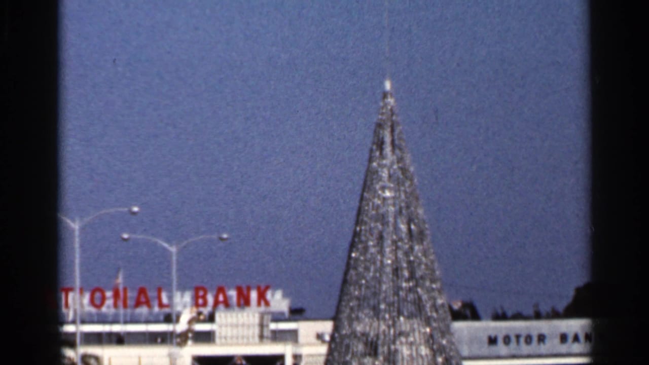 8mm frame of a tinseled Christmas tree partly blocking red National Bank lettering and Motor Bank signage.