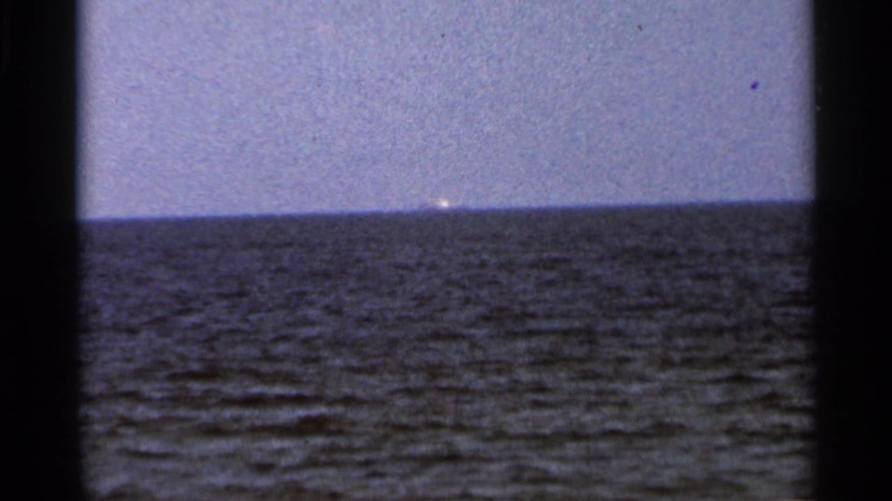 1966 Florida 8mm frame with open sea, a straight horizon, and a small bright distant vessel or structure.