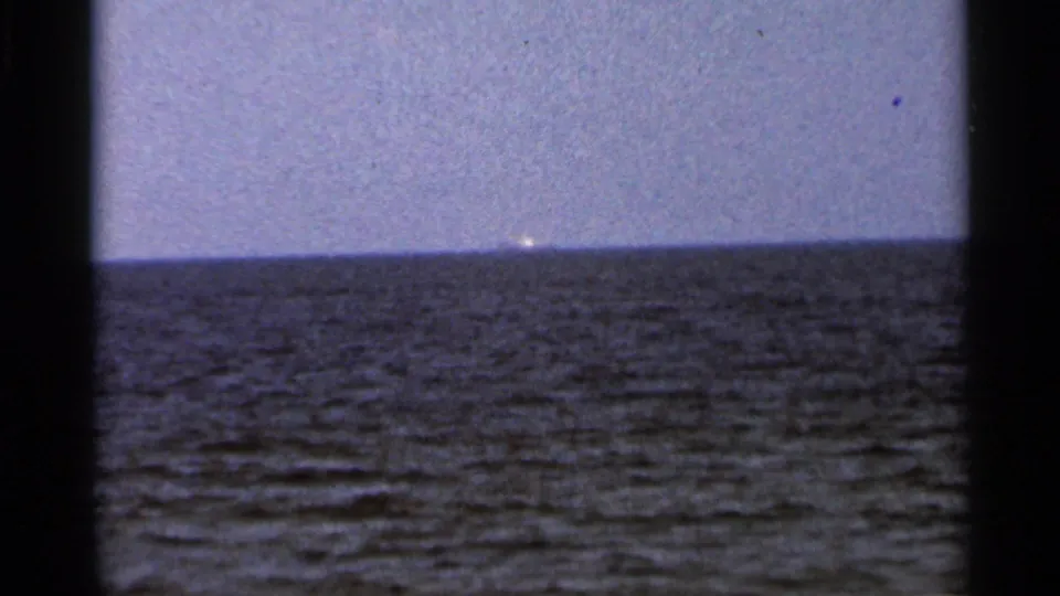 1966 Florida 8mm frame with open sea, a straight horizon, and a small bright distant vessel or structure.