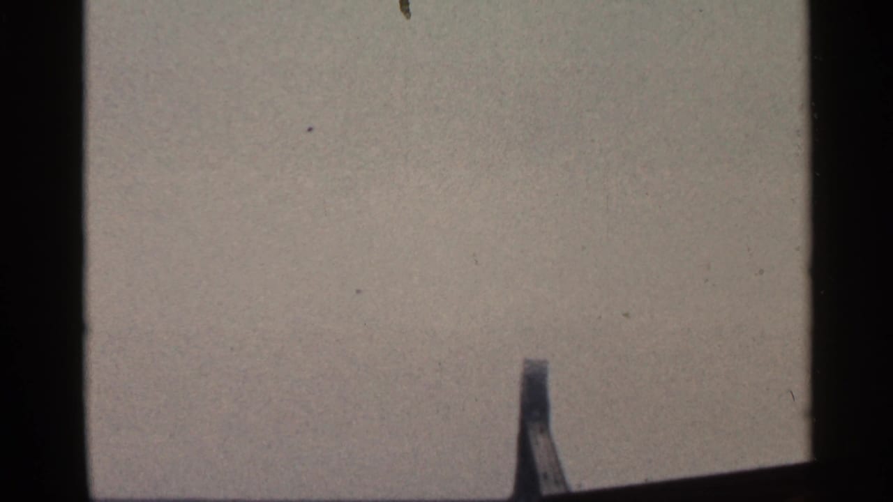 1966 Florida 8mm frame with dark gate borders, muted sky, and a slender mast or marker partly visible near the bottom edge.