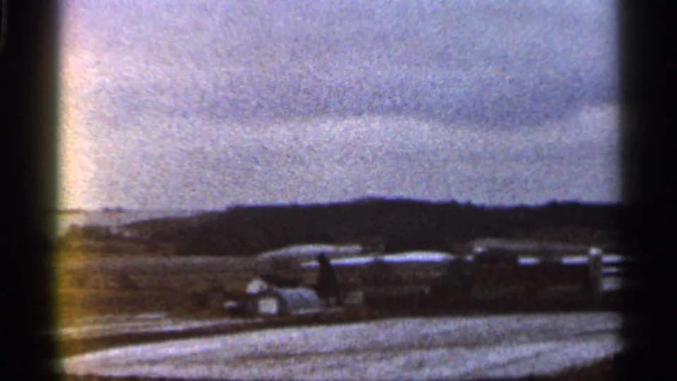 A 1966 Georgia roadside view with several vintage cars parked across open ground below distant hills.