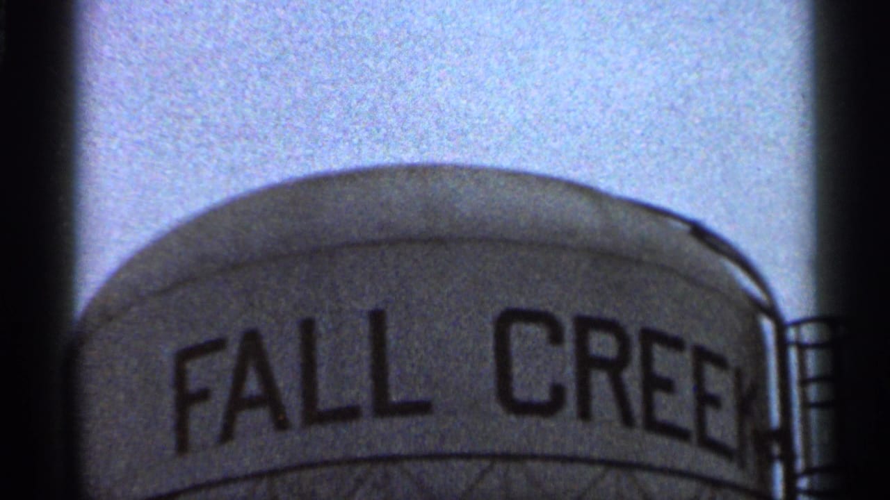 1966 Georgia 8mm frame showing the upper curve of a water tower with partial FALL CREEK lettering and dark film edges.