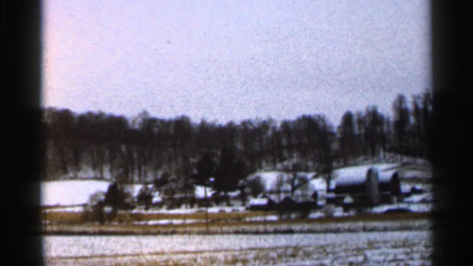 1966 Georgia rural landscape with snow-covered fields, barns, houses, and leafless trees under a pale winter sky.