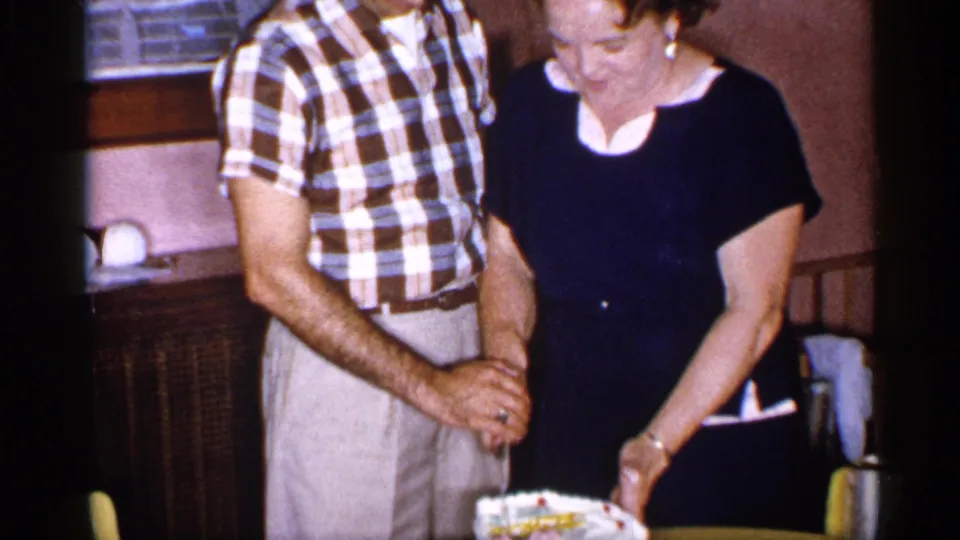 The couple appears to guide the knife together over a frosted cake in a 1955 New York private indoor celebration.