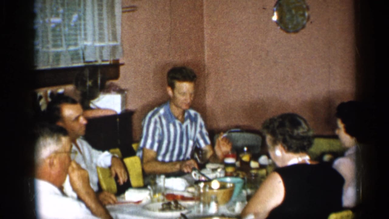 Adults seated around a dining table in a private home interior.