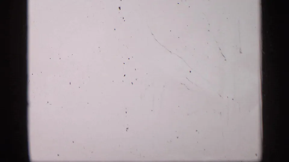 Pale 8mm end frame with minimal image content, visible surface marks, scratches, and black film-frame borders.