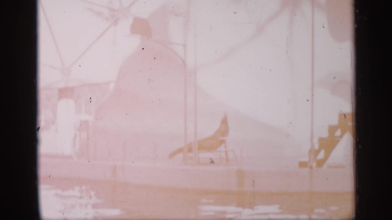 Faded frame of a circus platform and red stairs, with the seal act barely visible through overexposure.