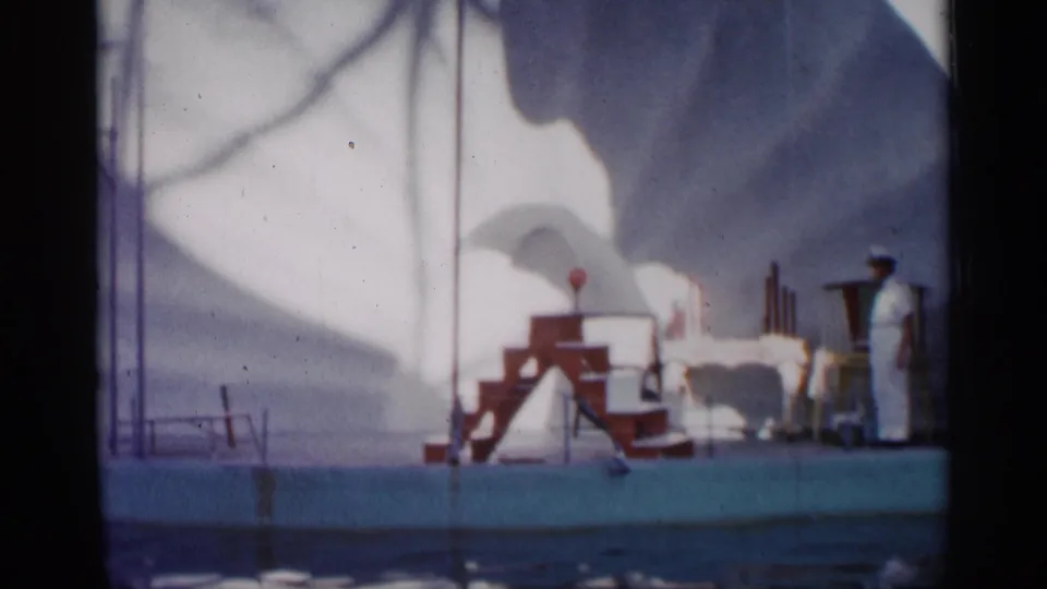 Faded 8mm frame from Alabama-labeled 1958 footage showing the red performance steps, ball target, and a sea lion partly hidden near the deck platform.