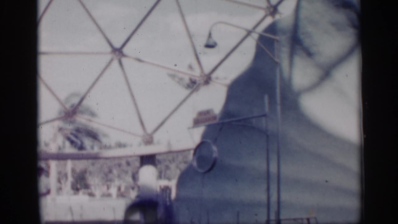 1958 Alabama frame of the marine show setting, with a trainer near the pool and a curved wall beneath a dome-like background structure.