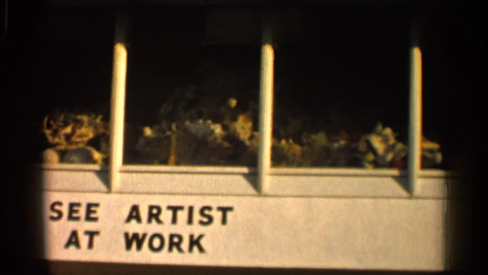 1958 Alabama 8mm frame centered on SEE ARTIST AT WORK text below a shellcraft display window.
