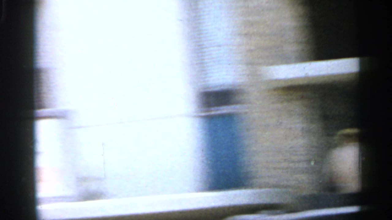 Overexposed 1958 Florida street view with blurred building fronts and windows seen from a moving vehicle.