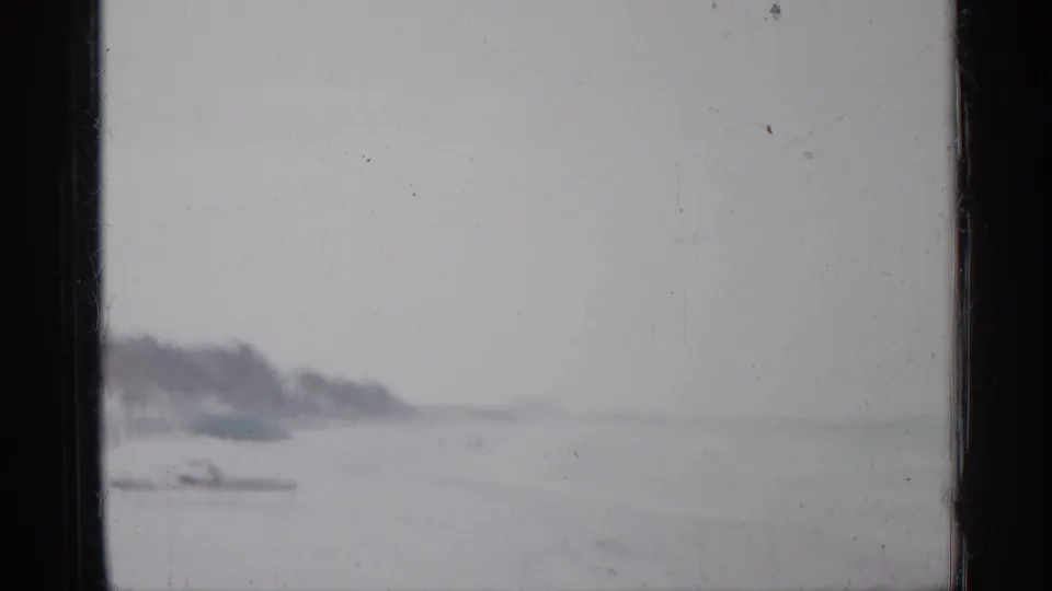 1958 Florida 8mm frame showing a hazy shoreline, rough water, distant land, and visible film borders.