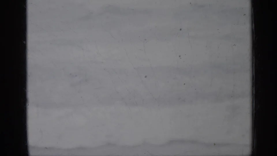 Overexposed 1958 Florida 8mm home-movie frame with dark gate edges, pale surface detail, dust, scratches, and no identifiable subject.
