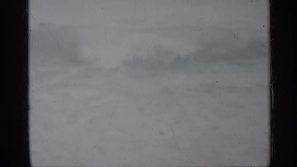 1958 Florida 8mm frame showing a flat ocean horizon and faint surf bands under a pale overcast sky.
