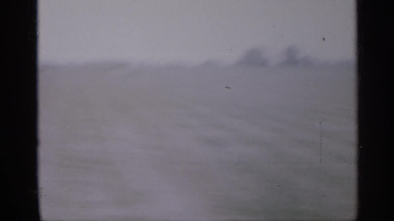 Soft, hazy view of an open lot with a pale sky and dark film-frame edges.