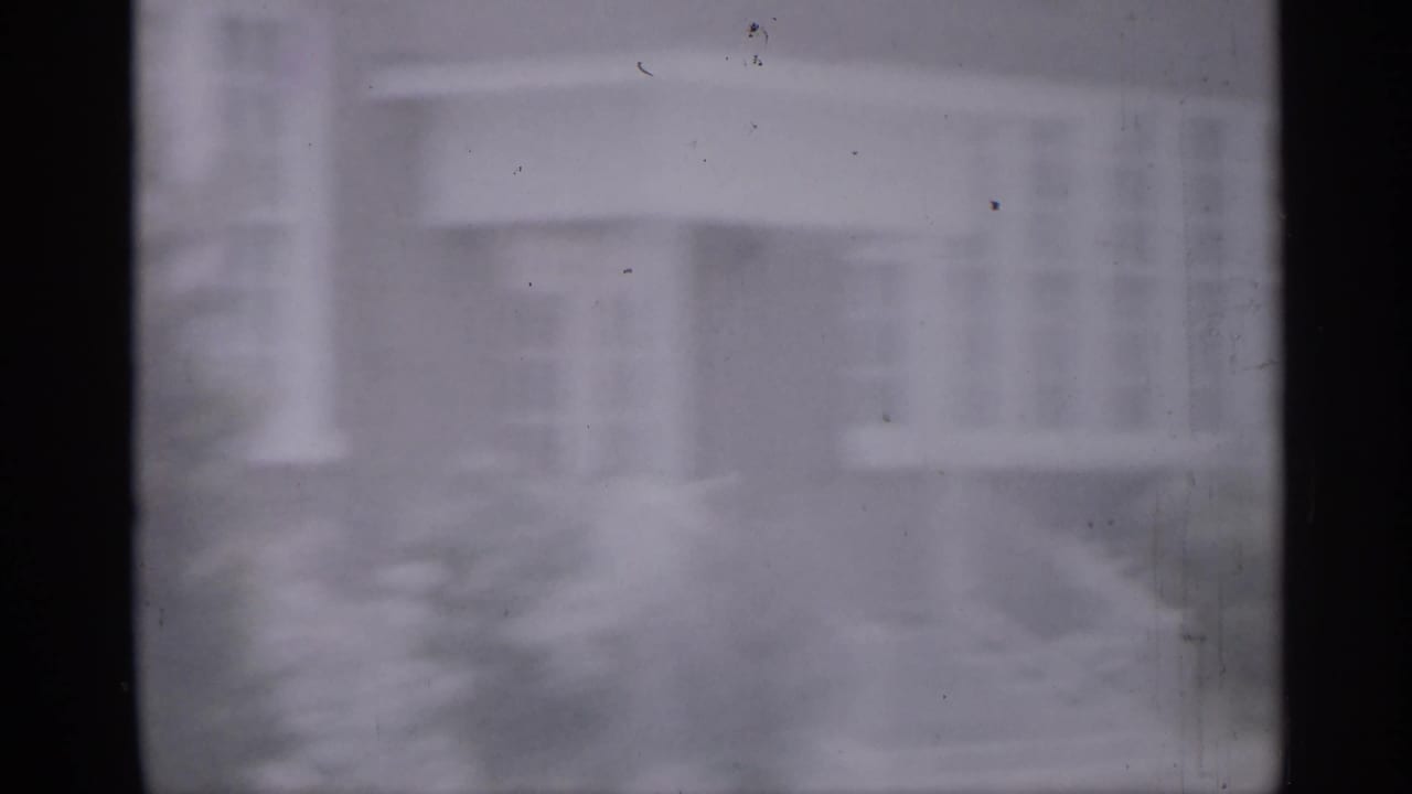 Hazy 1958 New Jersey school or civic-building entrance with steps and railings viewed through dark frame bars.