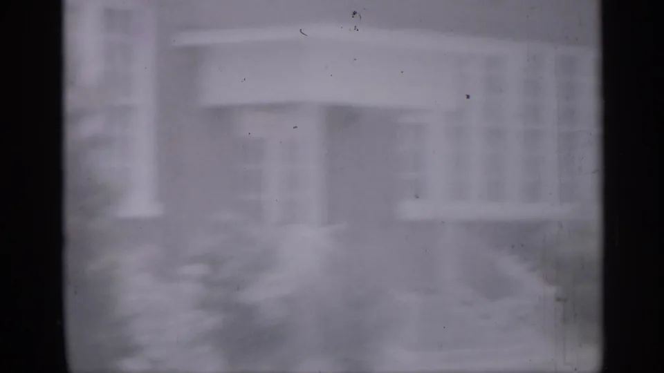 Hazy 1958 New Jersey school or civic-building entrance with steps and railings viewed through dark frame bars.