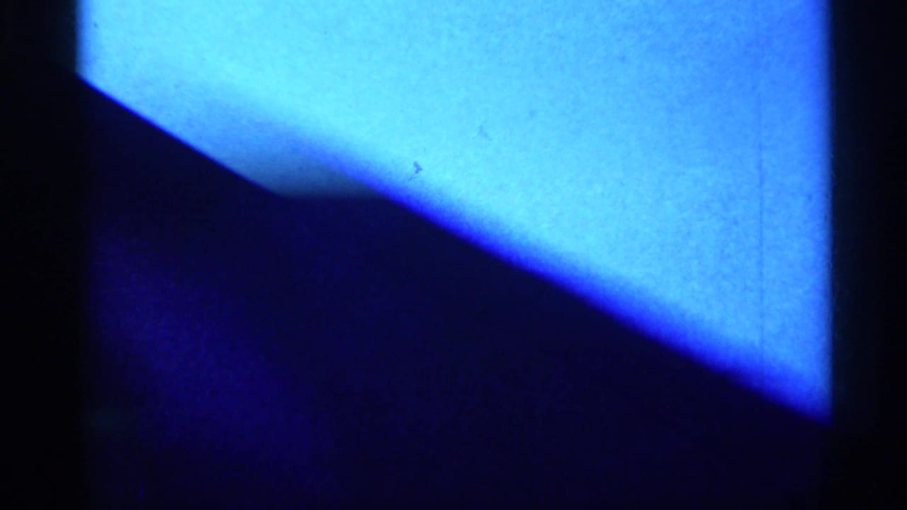 Blue, high-contrast 8mm frame with a dark diagonal form and vertical black divider, likely part of the same close-up.