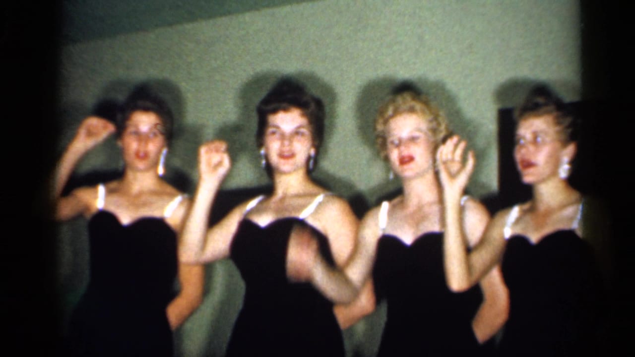 Four adult women continue the coordinated hand movement, framed closely in warm 8mm footage from New Jersey in 1958.