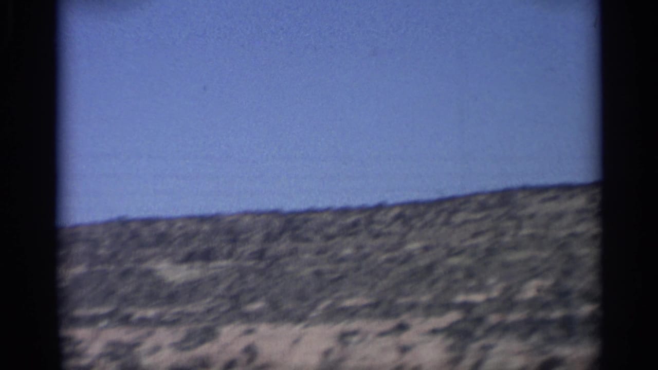 Arizona desert ridge and pale sandy ground pass through the 1959 8mm home-movie frame.