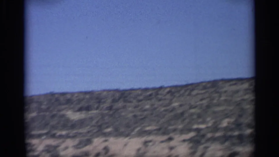 Arizona desert ridge and pale sandy ground pass through the 1959 8mm home-movie frame.