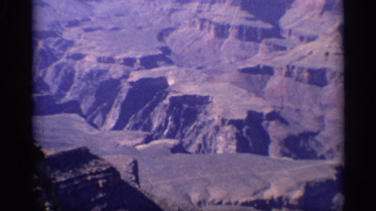 High aerial view of broad canyon shelves and deep shadowed channels.