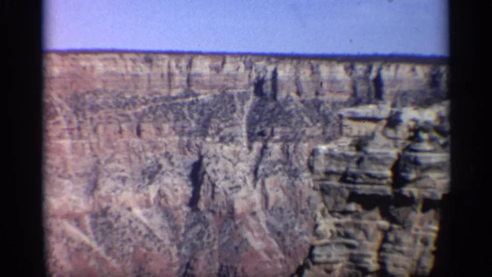 1959 Arizona canyon view with rugged cliff texture, deep vertical cuts, and a projecting rock outcrop near the right edge.