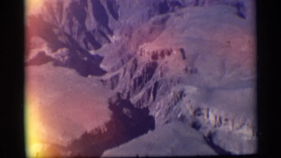 1959 Arizona 8mm frame of canyon rock formations, pale arid slopes, and deep shadows during a zooming landscape shot.