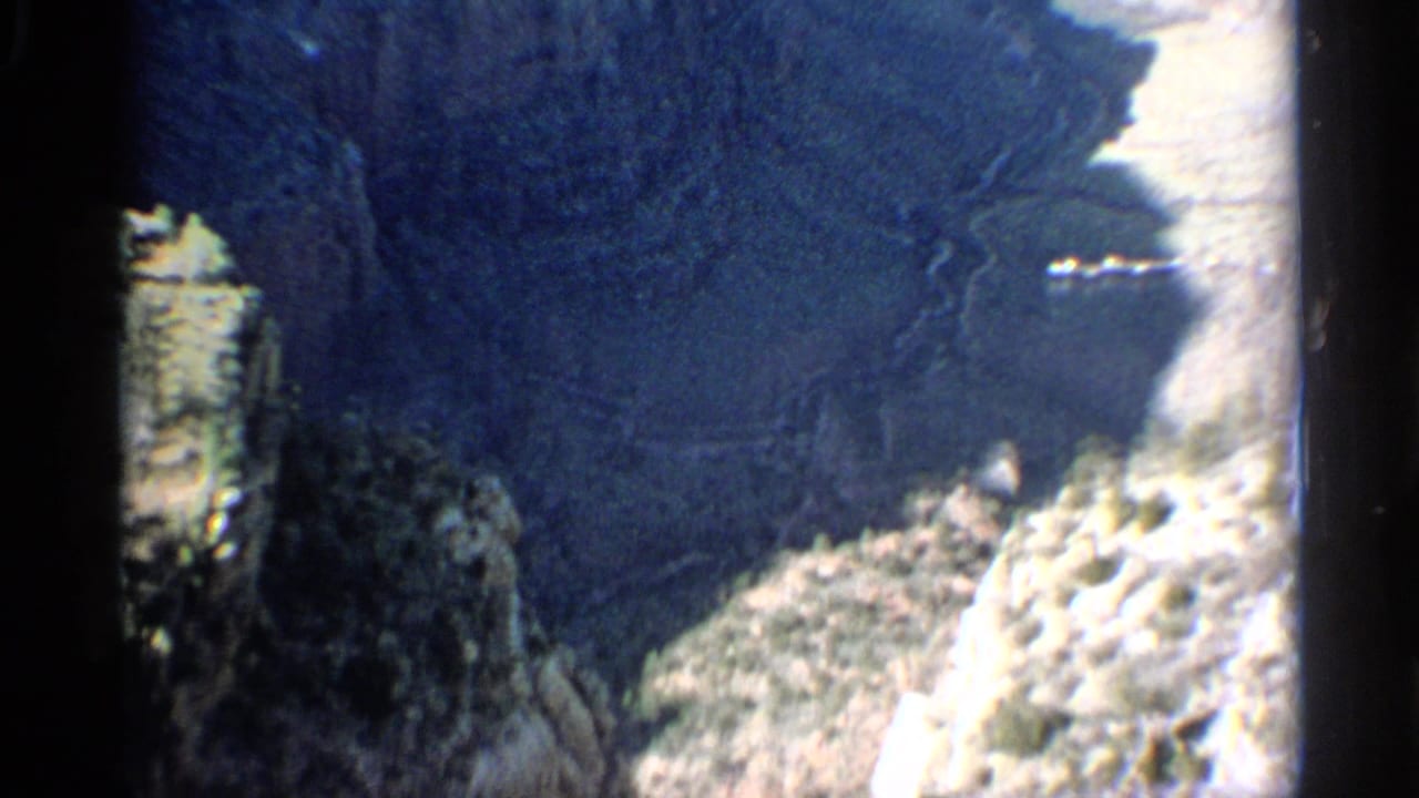 Rocky canyon edge with shadowed cliffs and a bright pale stone face.