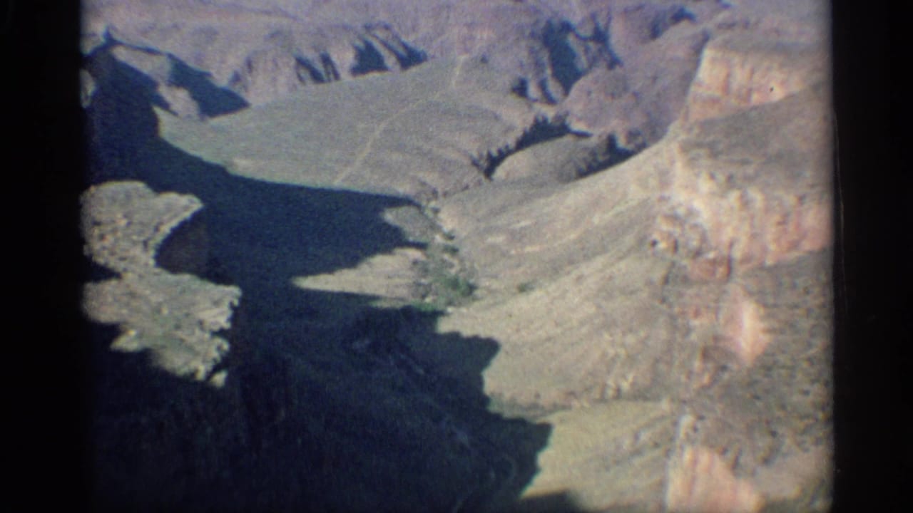 High aerial view of desert mountains with a dark canyon basin below.