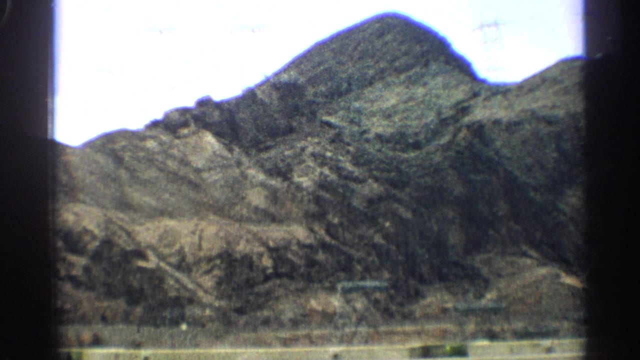 Rocky desert mountain slope seen through film frame edges.